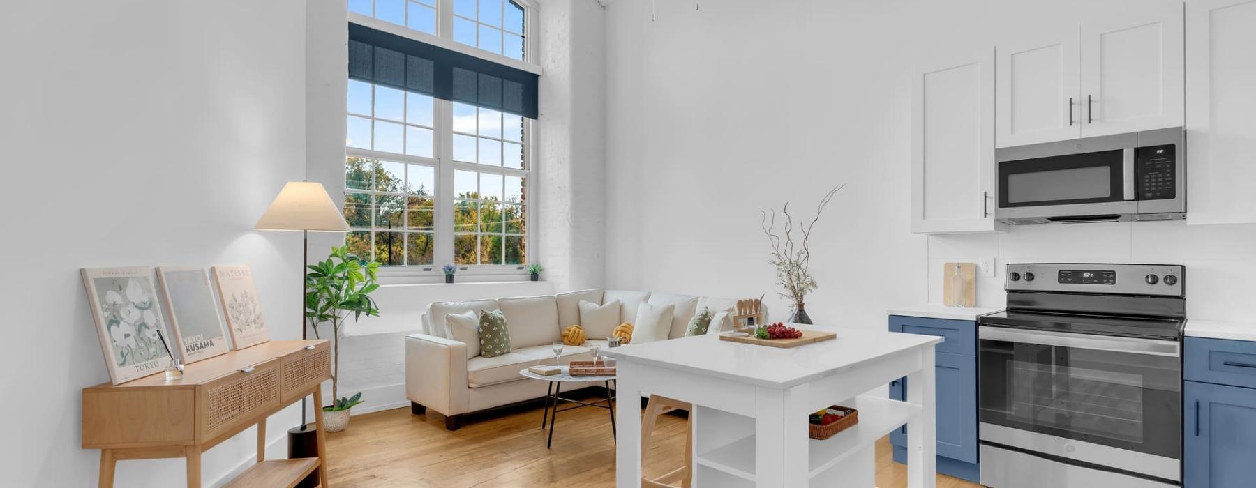 a living room with a white couch and a table near a kitchen